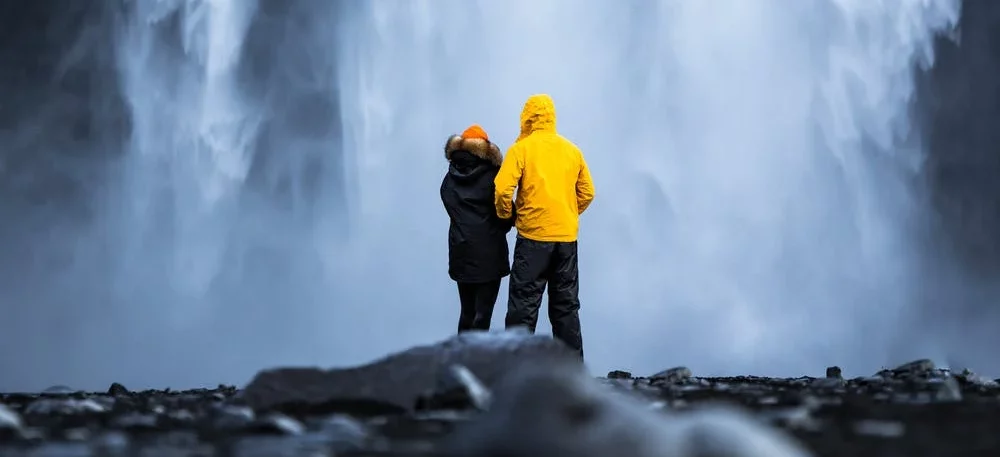 Мужчина с девушкой смотрят на водопад